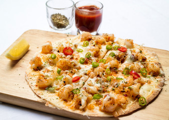 crispy pizza seafoo, mozzarella cheese, salmon with hot and spicy fresh chili served with tomato sauce and herbs
