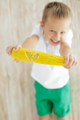 The child eats delicious corn at home 