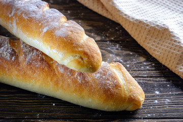 Fresh French loaf with a ruddy crust on a wooden table