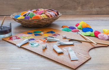 Painted sea shells. Color pallet with paint brush on a wooden table.