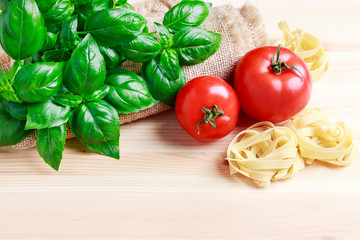 Basil plant and red tomatoes on wooden background