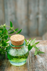 Myrtus (myrtle) essential oil and two candles in the background.