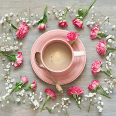 Obraz na płótnie Canvas Cup of creamy coffee with flowers decor