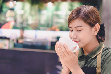 Young woman drinking coffee in cafe - Image