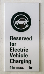 EV charging station wall sign. Electric vehicle charging point with time limitation for the parking 4 hours maximum