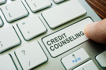 Man pushing button credit counseling on keyboard. Debt advice.