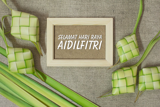 Ketupat (rice dumpling) with the wording of Selamat Hari Raya Aidilfitri on jute texture background. Ketupat is most popular food on Aidilfitri festival (Fasting Day of Celebration for Muslims)