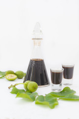 Bottle and two glasses with walnut liquor. Homemade wallnut liquer on white background, vertical image.