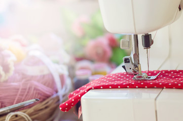 Close up of sewing machine working with red fabric