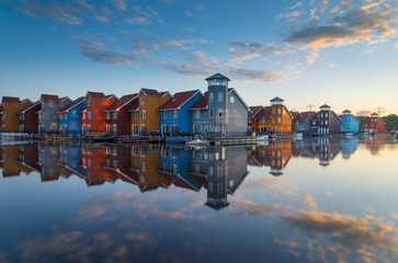 Tranquil sunrise at colorful wooden houses in a small marina in the Netherlands.  Living at the...