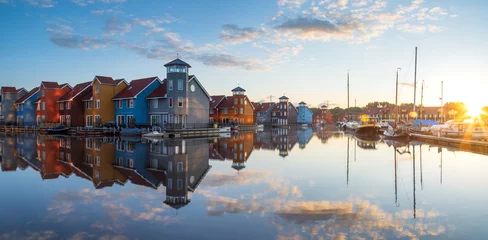 Fotobehang Tranquil dawn at colorful wooden houses in a small harbor in the Netherlands.  Living at the waterfront in Groningen. © sanderstock