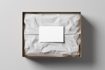 Open gift box with white wrapping paper and business card on a light background. Business gift. Mock up. Top view. 3d rendering