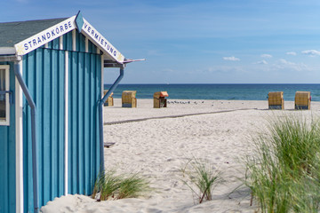 Wooden cabin on a beach on the German Baltic Sea coast, in the background beach chairs