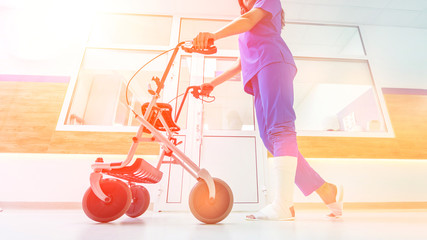 Patient on rollator with hand brakes moving in hospital