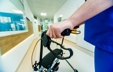 Patient on rollator with hand brakes moving in hospital