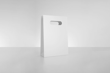 White paper bag mock up with handles on gray background. High resolution.