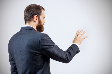 Businessman in suit shows outstretched hand withspread fingers.