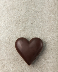 Obraz premium Chocolate heart on a stone background. Background for Valentine's Day.