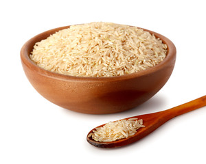 Wooden bowl and wooden spoon with white rice. Natural products, healthy food.