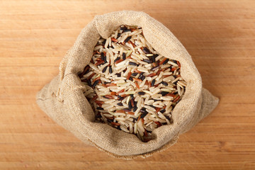Mixed rice in a pouch on a wooden background. Healthy food, natural product.