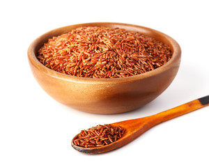 Bowl with red rice on white background