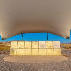 Square frame Concrete rectangular structure under a white canopy against vivid blue sky