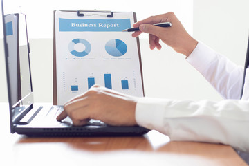 Businessman analyzing investment charts with laptop computer on office desk table.Close up.Financial Report Revenue Statistical Accounting Concept.