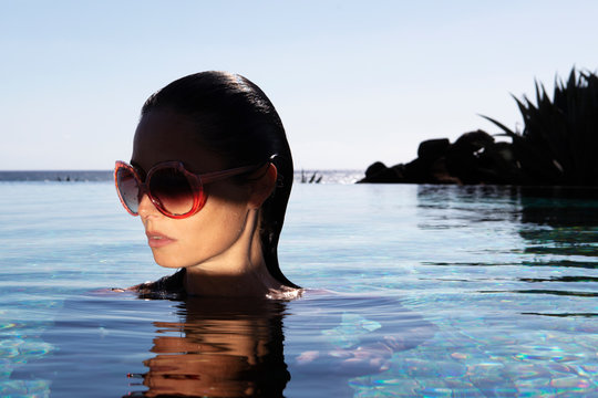 Jeune femme lunette, piscine au soleil