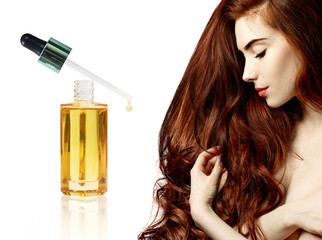 Obraz na płótnie Canvas Redheaded woman near goldden bottle with oil.