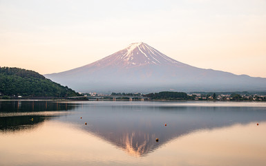 Obraz premium The reflection of beautiful Fuji mountain with bridge in lake in the summer, the famous landmark and attraction place of tourists who have a long holiday in Japan, Lake Kawaguchiko