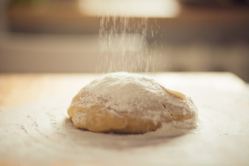 dough on a cutting board and pouring farina