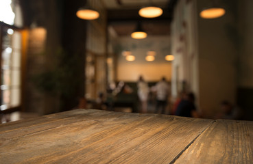 image of wooden table in front of abstract blurred background of resturant lights