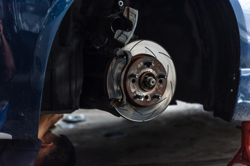 Disc brake and asbestos brake pads at car garage