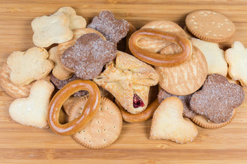 Pile of different sweet bakery products on a wooden surface