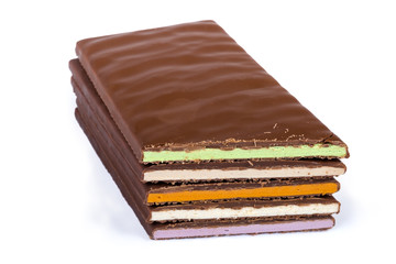Bars of milk chocolate with varicolored filling on white background
