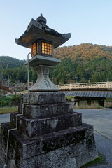 Fototapeta na wymiar 滋賀県の多賀町にある調宮神社の石灯籠と里山の風景