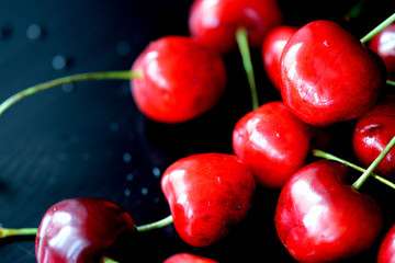 Ripe sweet cherry berries with water drops on a dark background close up