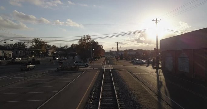 Following train tracks into town crossing at sunset
