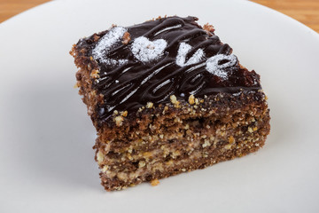 Slice of chocolate sponge cake on white dish close-up
