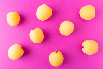 Apricots on a bright pink background. Summer ripe fruit. The concept of growing fruits, natural food rich in vitamins. Minimalism, flat lay, top view, design.