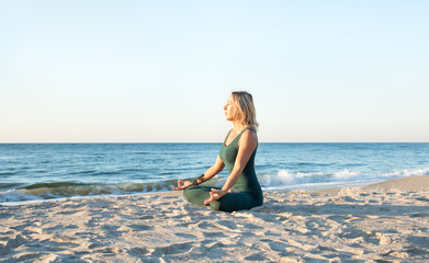 caucasian healthy woman with beautiful body doing yoga at sunrise on the beach, yoga poses