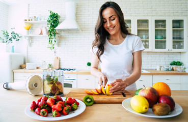 Beautiful woman making fruits smoothies with blender. Healthy eating lifestyle concept portrait of...