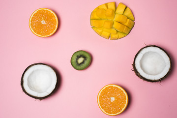  Tropical fruits. Coconut, orange, mango, kiwi on a pink background. Summer season