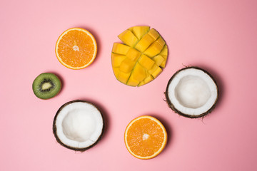 Obraz na płótnie Canvas Tropical fruits. Coconut, orange, mango, kiwi on a pink background. Summer season
