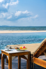 Vertical photo of delicious breakfast on the peaceful beach