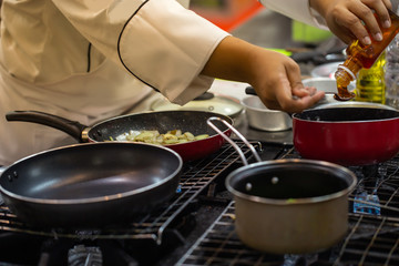 Chef pouring honey to teaspoon for cooking sauce in pot. Homemade cooking food