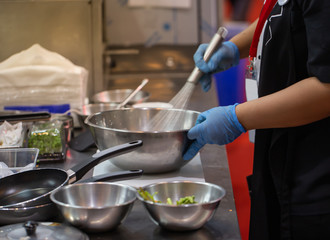 Chef beating food with whisk in a stainless steel bowl. Homemade cooking food