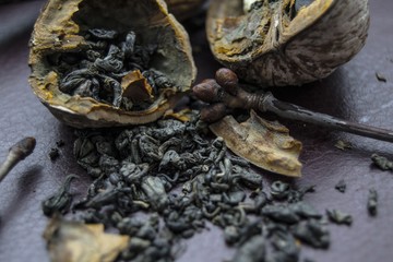 green tea leaves in a bowl on wooden table