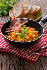 Scrambled egg with tomato sliced, bacon grill on pan and breads, Homemade Breakfast.