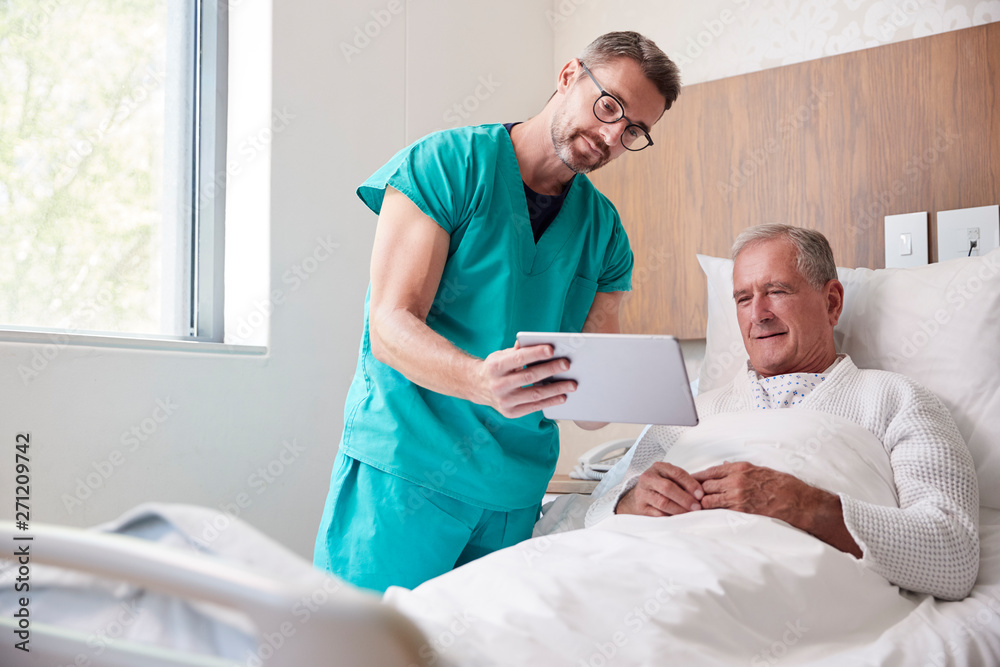 Wall mural Surgeon With Digital Tablet Visiting Senior Male Patient In Hospital Bed In Geriatric Unit